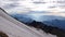 Morning and daybreak atmosphere in the Alps of Switzerland with a steep glacier in the foreground and rows of hazy mountains behin