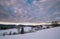 Morning dusk countryside hills, groves and farmlands in winter remote alpine mountain village