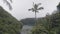 Morning fog over lake and green tropical forest on hills. Misty haze and tropical lake among green highland and mountain