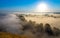 Morning foggy valley with river, hills and withered grass