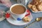 Morning hot chocolate in the original white Cup with a blue button on the background of biscuits. Invigorating Breakfast