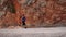 Morning jogging in mountains. Energetic athletic woman exercising outdoors. Young female running up rocky mountain cliffs. Young a