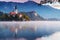 Morning at lake Bled. Church on island with castle and mountains in background