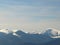 Morning landscape with mountains and blue sky. Evening sunset on the horizon of hills with white snow and cloud