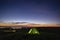 Morning landscape, tent against the backdrop of the sunset and city lights on a hill in Ukraine