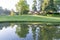 Morning light reflects lodge buildings in calm pond across beautifully landscaped grounds