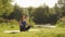 Morning meditation in park. Woman practicing yoga at sunrise outdoors. Female sitting on yoga mat in lotus position and meditation