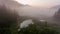 Morning mists rising above forest lake.