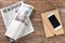 Morning newspapers and mobile phone on wooden table