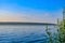 Morning panorama view over river from fishing place to opposite bank, reflection of sky in the water level