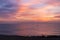 Morning pink sky reflected in the sea. A small lonely fisherman boat silhouette sailing during the sunrise. Soft color