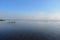 Morning river fog creeps over the water beautiful view blue sky clouds reflected in the water