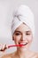 Morning routine. Girl after shower brushing her teeth on white background.