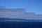 Morning at sea: Clouds and fog in a deep blue sky over Alaskan islands