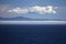 Morning at sea: Clouds and fog in a deep blue sky over Alaskan islands