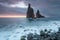 Morning seascape sunrise of Madeira. Rocky shore, silhouette of two steep cliffs and misty rocks hit by waves. Long exposure.