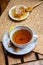 Morning setup on wooden table at balcony for morning relaxation with books, cup of tea, teapot, organic honey, green tea leaves