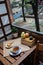 Morning setup on wooden table at balcony for morning relaxation with books, cup of tea, teapot, organic honey, green tea leaves