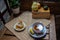 Morning setup on wooden table at balcony for morning relaxation with books, cup of tea, teapot, organic honey, green tea leaves