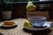 Morning setup on wooden table at balcony for morning relaxation with books, cup of tea, teapot, organic honey, green tea leaves