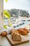 Morning in summer Provence, breakfast with fresh baked croissants and baquett bread and view on fisherman`s boats in harbour of