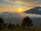 The morning sun appears behind the clouds and mountains with beautiful morning clouds between the mountains