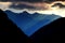 Morning sun rays over a steep valley and peaks of Gailtal Alps