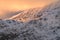 Morning sunlight on Winter snowcapped mountains in the Lake District with beautiful clouds.