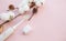 Morning teeth and face care. cotton flower, toothbrush and floss. top view flat lay on pink background