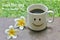 Morning text greeting - Good Morning. Have a beautiful Day. A cup of coffee with happy smiling sign emoticon on it and flower.