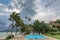 Morning in tropical hotel, with palm tree and swimming pool at wind day