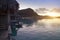 Morning on the tropical island. The sun ascends behind the mountain over a reed roof of a hut at the ocean