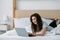 morning video call relaxed woman using laptop bed