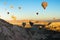 Morning view of air balloons festival in Cappadocia. Hot air balloons fly over rocks. Scenic landscape with unusual rock formation