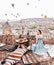 Morning view in Cappadocia. Terrace view in Goreme woman with hot air balloons and carpets