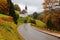 Morning view of Church Maria Gern on the autumn hillside with a curving road passing by