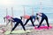 Morning yoga on beach, group of young females