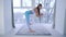 Morning yoga exercise, healthy girl balances near window indoors
