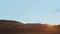 Moroccan bedouin with camels silhouettes in sand dunes of Sahara desert. Caravan in Sahara desert travel tourism