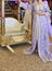 A Moroccan bride sits on the wedding chair in the traditional Moroccan dress. The caftan