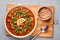 Moroccan Harira Soup in white plate on woden board on grey concrete table top. Ramadan Iftar Food