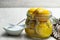 Moroccan preserved salted lemons in glass jar on white wooden table