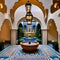 A Moroccan riad-inspired courtyard with mosaic tile flooring, a central fountain, and intricate archways2, Generative AI