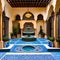 A Moroccan riad-inspired courtyard with mosaic tile flooring, a central fountain, and intricate archways3, Generative AI