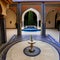 A Moroccan riad-inspired courtyard with mosaic tile flooring, a central fountain, and intricate archways4, Generative AI