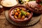 Moroccan tagine with rice served in a dish isolated on wooden background side view