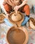 Moroccan woman grinding argan kernels into thick brown oily liquid.