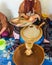 Moroccan woman shows argan kernels and put them into the grinder, Morocco.