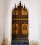 Moroccan wooden painted door set inside a carved plaster doorway