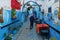 Morocco. Chefchaouen. A woman dressed in a djellaba walking in a blue street of the medina